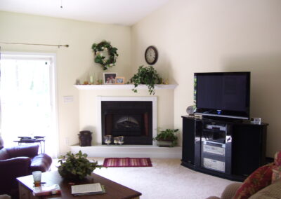 new gas fireplace in living room with white wood mantel and surround
