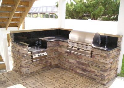 outdoor kitchen on back porch with built-in grill
