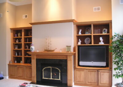 new gas fireplace in living room with light wood surround and mantel